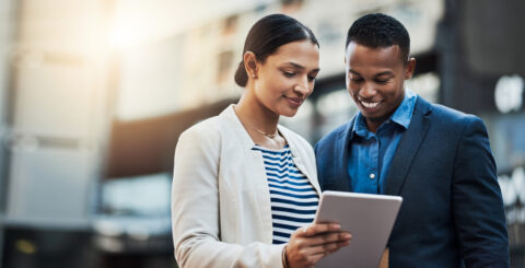 The future of business lies in how well youre connected. Shot of two businesspeople using a digital tablet in the city.